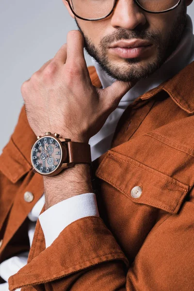 Обрізаний вид стильного чоловіка в теракотовій куртці і наручних годинниках ізольовані на сірому — стокове фото