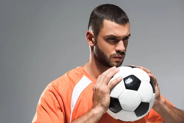 Serious sportsman in sportswear holding football isolated on grey — Stock Photo