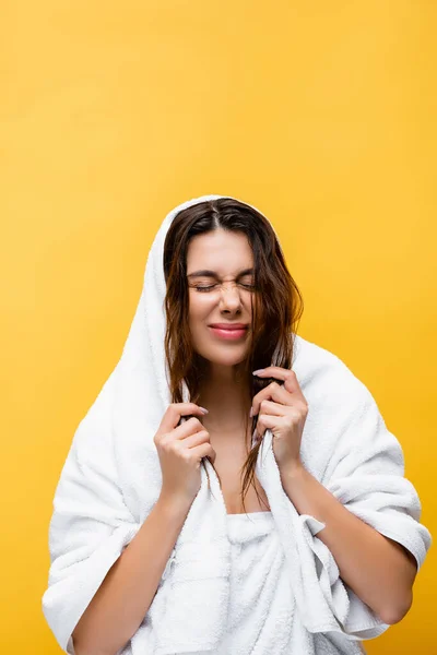 Belle femme aux yeux fermés, cheveux mouillés et serviette isolée sur jaune — Photo de stock