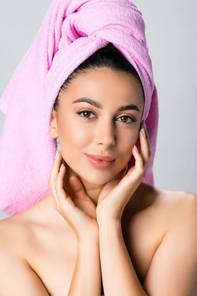 Bella donna con asciugamano su capelli toccante viso isolato su grigio — Foto stock