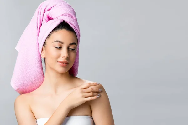 Beautiful woman with towel on hair touching skin isolated on grey — Stock Photo