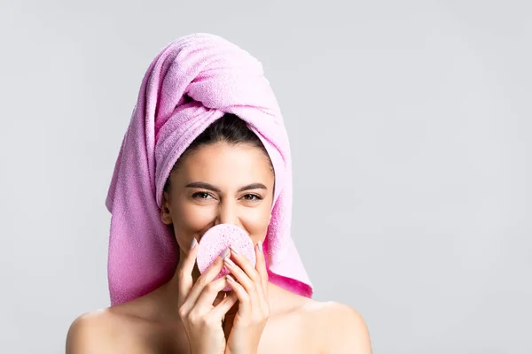 Bella donna sorridente con asciugamano su capelli e spugna isolata su grigio — Foto stock