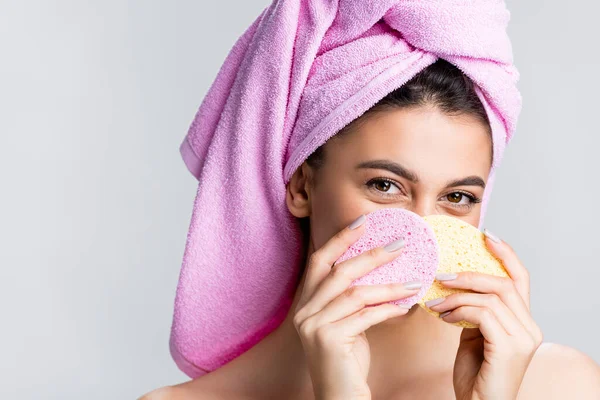 Bella donna con asciugamano su capelli che tengono spugne isolate su grigio — Foto stock