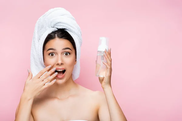 Scioccato bella donna con asciugamano sui capelli e schiuma detergente isolato su rosa — Foto stock