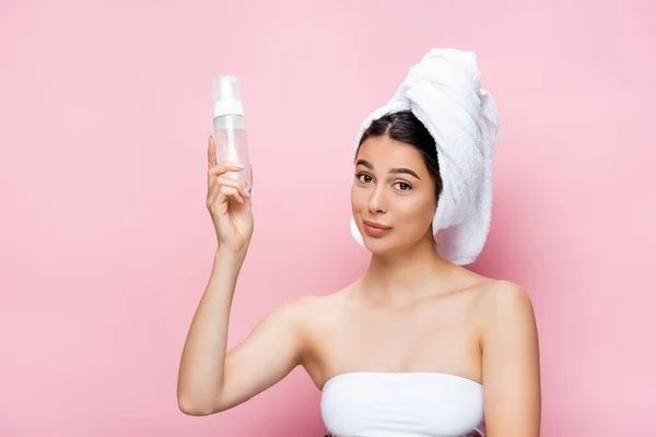 Bella donna con asciugamano su capelli e schiuma detergente isolata su rosa — Foto stock