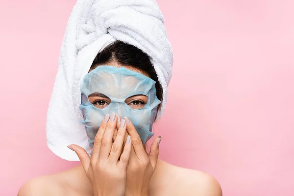 Risa hermosa mujer con máscara hoja en la cara aislado en rosa - foto de stock