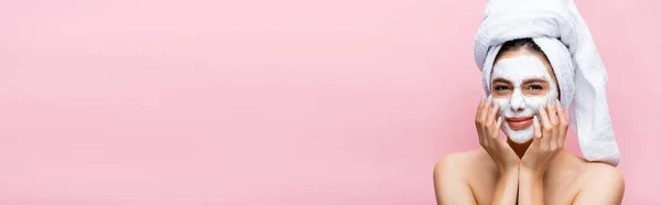 Schöne Frau mit Handtuch auf dem Kopf und Tonmaske auf dem Gesicht isoliert auf rosa, Banner — Stockfoto