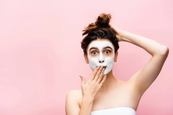 Überrascht schöne Frau mit Tonmaske im Gesicht isoliert auf rosa — Stockfoto