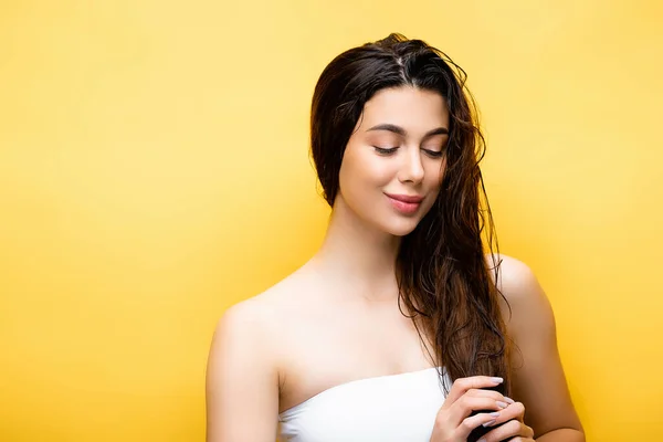 Sourire belle femme aux cheveux mouillés isolé sur jaune — Photo de stock