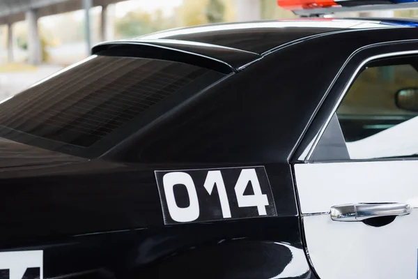 Voiture de patrouille avec numéro sur fond flou à l'extérieur — Photo de stock