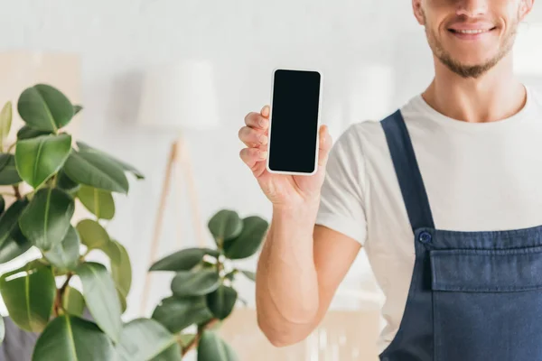 Cropped view of happy mover holding smartphone with blank screen — Stock Photo