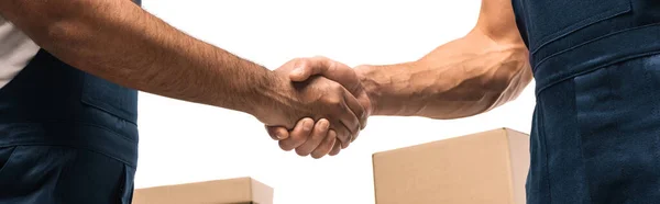 Vista cortada de movers apertando as mãos perto de caixas isoladas em branco, banner — Fotografia de Stock