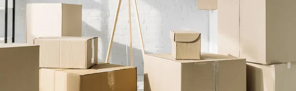 Stack of carton boxes in modern apartment, banner — Stock Photo