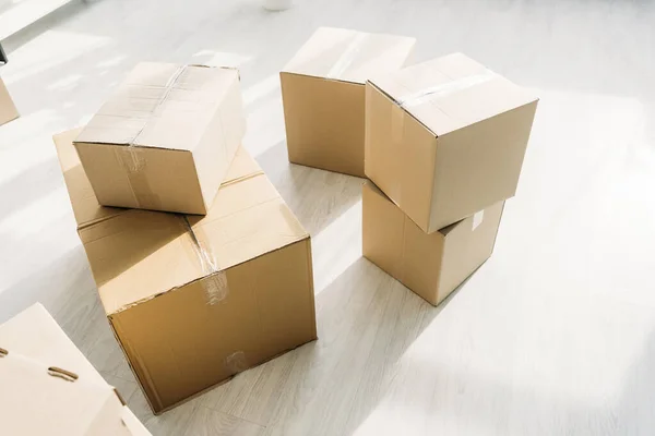 Stacked carton boxes on floor in modern apartment — Stock Photo