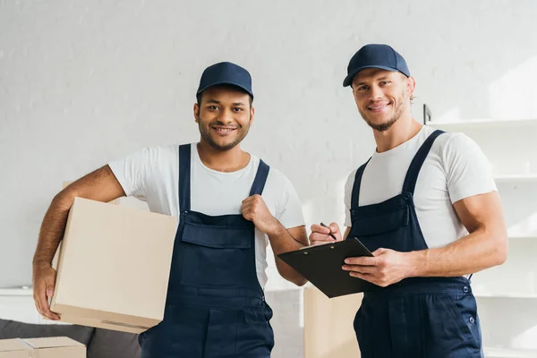 Alegre multicultural se mueve sonriendo mientras mira la cámara en el apartamento - foto de stock