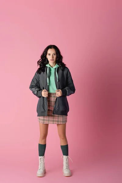 Brunette young woman in casual winter outfit posing on pink background — Stock Photo