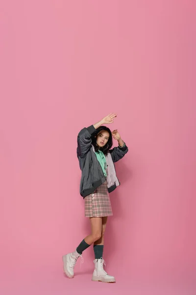 Brunette young woman in casual winter outfit posing on pink background — Stock Photo
