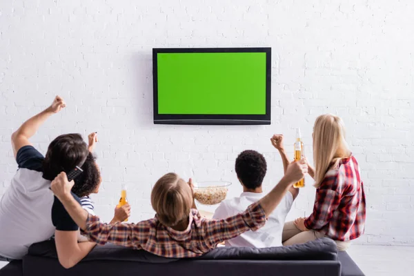 Visão traseira de fãs de esportes multiculturais animado mostrando gesto de vitória enquanto assiste campeonato na tv — Fotografia de Stock