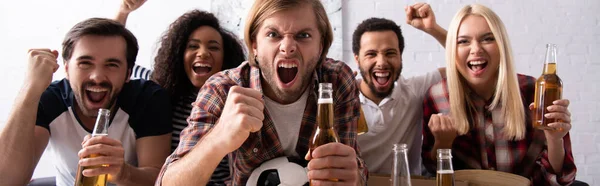 Aficionados al fútbol emocionados gritando y sosteniendo la cerveza mientras ve el campeonato en casa, pancarta - foto de stock