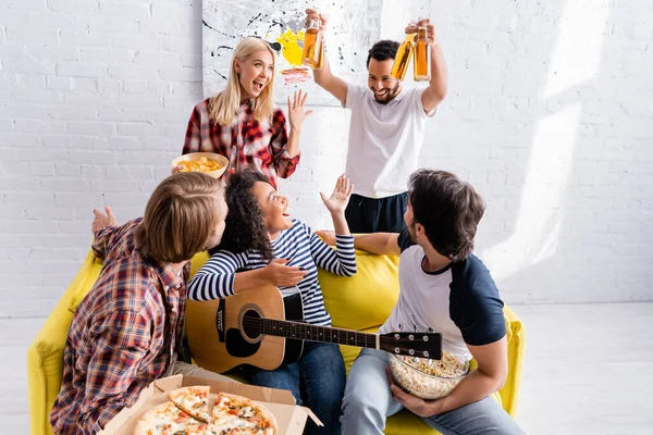 Homme afro-américain tenant de la bière près de joyeux amis multiethniques pendant la fête — Photo de stock