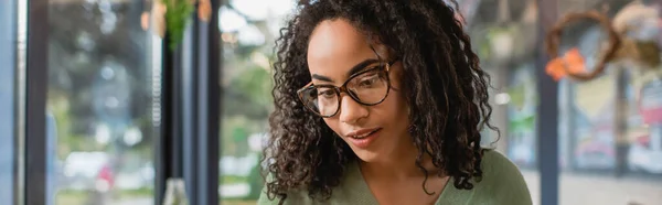 Curly and young african american woman in glasses, banner — Stock Photo
