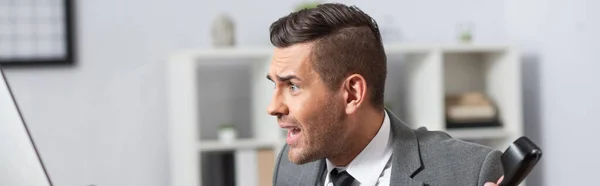 Shocked trader screaming while holding handset in office, banner — Stock Photo