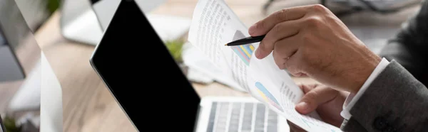 Cropped view of trader pointing with pen at laptop with blank screen, banner — Stock Photo