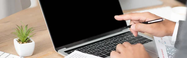 Partial view of businessman pointing with finger at laptop, banner — Stock Photo