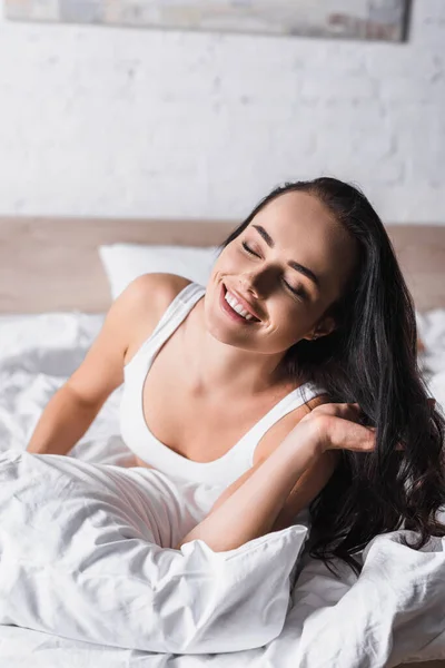 Feliz joven morena mujer en la cama - foto de stock