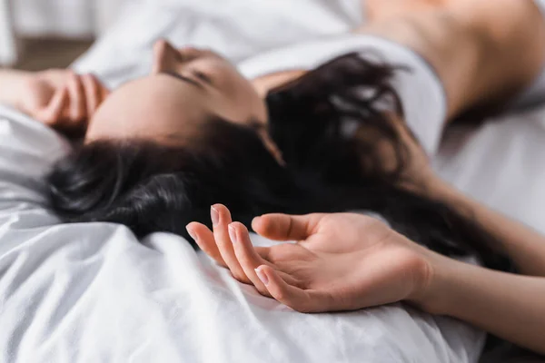 Young brunette woman lying in bed — Stock Photo