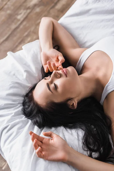 Draufsicht auf junge brünette Frau, die im Bett schläft — Stockfoto