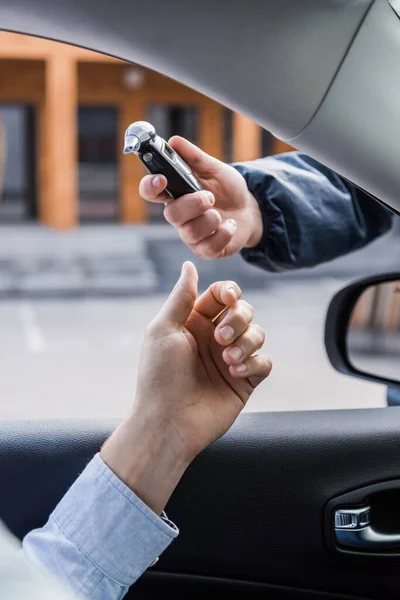 Cropped view of policeman giving breathalyzer to driver in car — Stock Photo