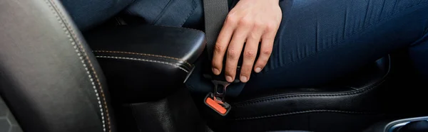Обрізаний вид людини, що замикає ремінь безпеки в машині, банер — стокове фото