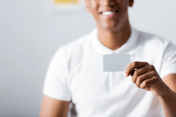 Carte blanche en main du thérapeute afro-américain joyeux sur fond flou — Photo de stock