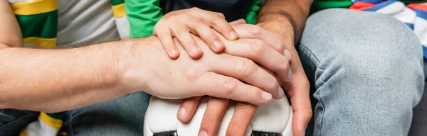 Partial view of boy, father and grandfather putting hands on soccer ball together, banner — Stock Photo