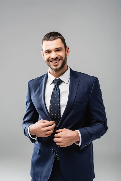 Empresário alegre no desgaste formal sorrindo para a câmera isolada no cinza — Fotografia de Stock