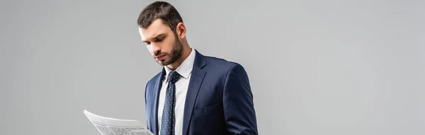 Pensativo hombre de negocios leyendo periódico aislado en gris, bandera - foto de stock