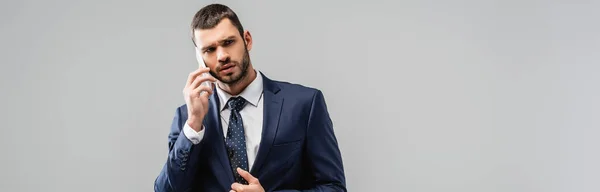 Seriöser Geschäftsmann spricht auf Smartphone isoliert auf grauem Banner — Stockfoto