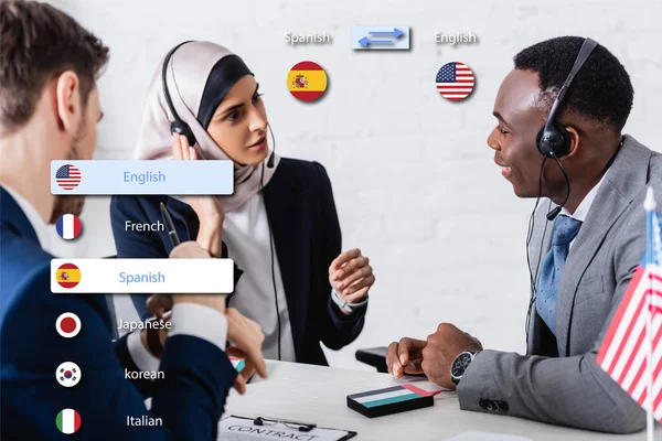 Interracial business partners in headsets near digital translator on blurred foreground, translation application interface illustration — Stock Photo