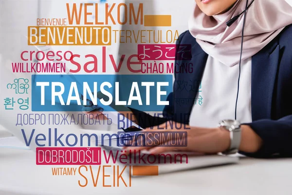 Cropped view of arabian interpreter typing on laptop, translate lettering near words in different languages illustration. Translation: 