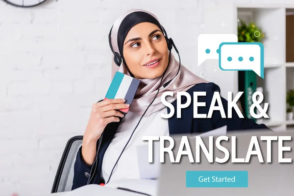 Щасливий арабський перекладач в гарнітурі, що тримає цифровий перекладач, говорить і перекладає написи біля бульбашок мовлення і починає ілюстрацію піктограм — стокове фото