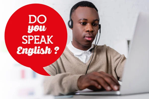 African american interpreter working on laptop on blurred foreground, speech bubble with do you speak english question illustration — Stock Photo