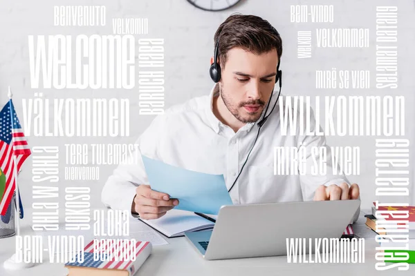 Traducteur dans casque travaillant près de l'ordinateur portable et drapeau des Etats-Unis, mot de bienvenue dans différentes langues illustration — Photo de stock