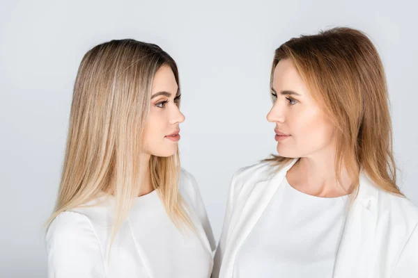 Mother and daughter looking at each other isolated on grey, generation of women — Stock Photo