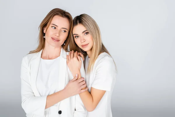 Junge Tochter umarmt Mutter auf grau, Generation von Frauen — Stockfoto