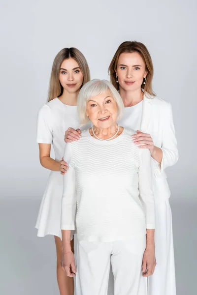 Mutter und Tochter neben lächelnder Oma auf grau, Generation von Frauen — Stockfoto