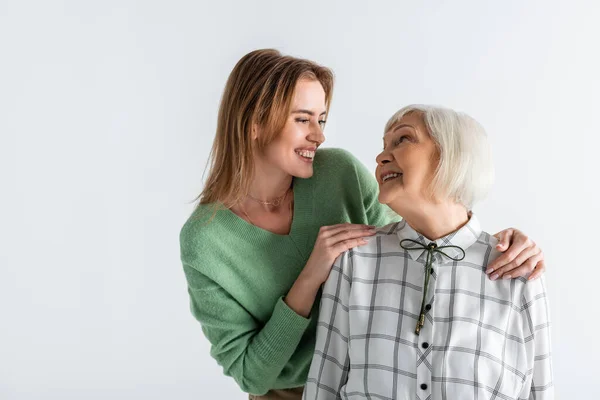 Generation glücklicher Frauen lächelt, während sie einander isoliert auf Weiß ansieht — Stockfoto