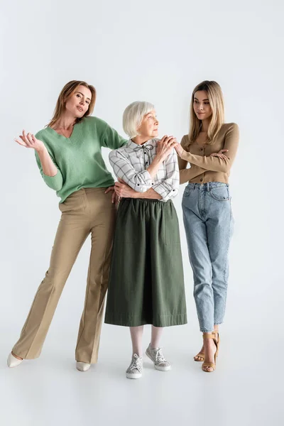 Longitud completa de tres generaciones de mujeres posando en blanco - foto de stock