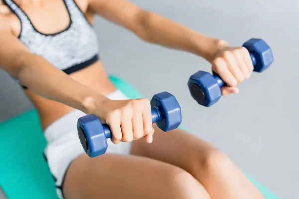 Vista cortada de Africano americano desportista fazendo exercício abs com halteres, fundo borrado — Fotografia de Stock