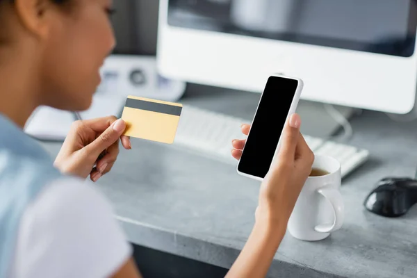 Cropped view of african american woman holding smartphone with blank screen and credit card — Stock Photo